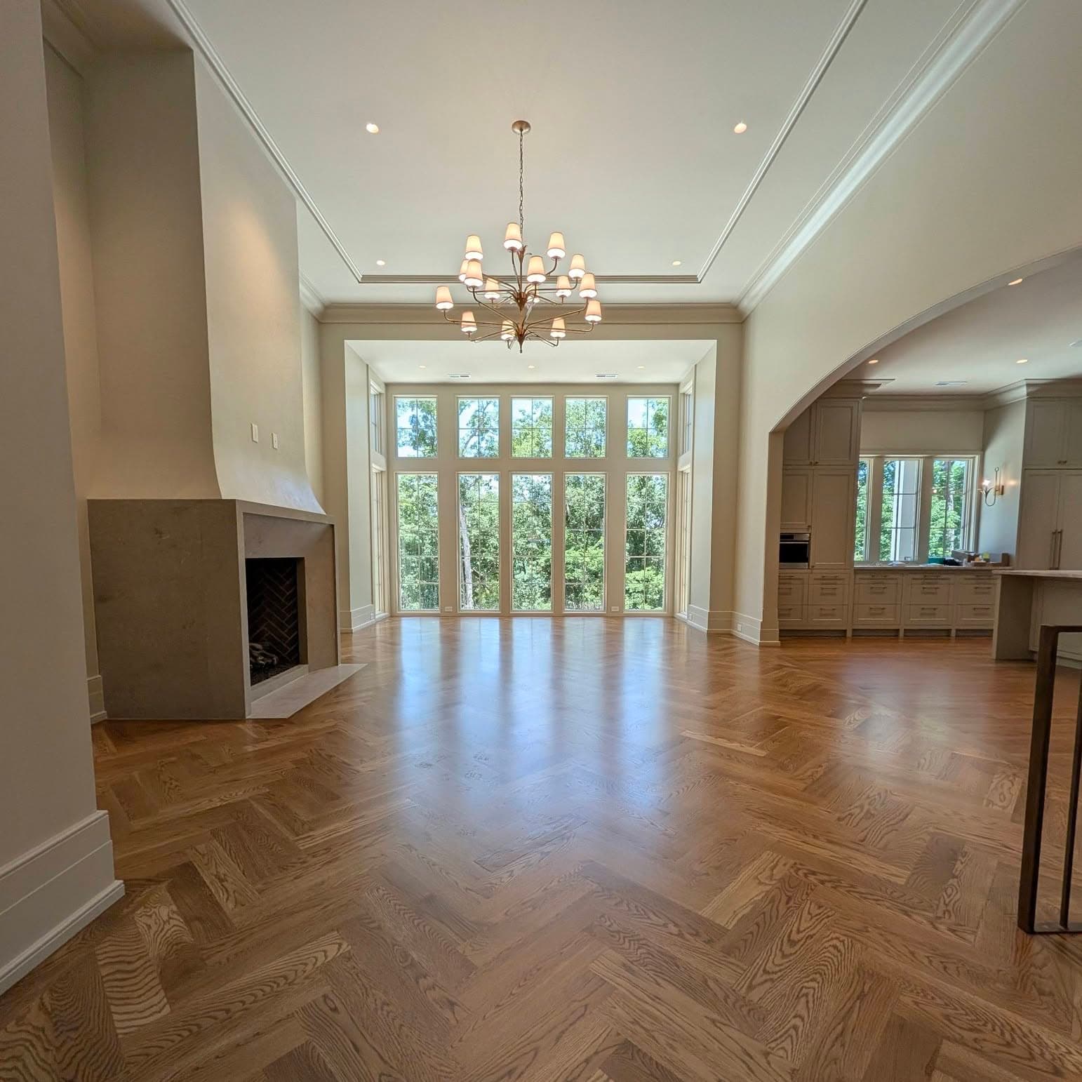 Herringbone oak hardwood floor in a great room with a wall of windows, a job by Alabama Hardwood Restoration